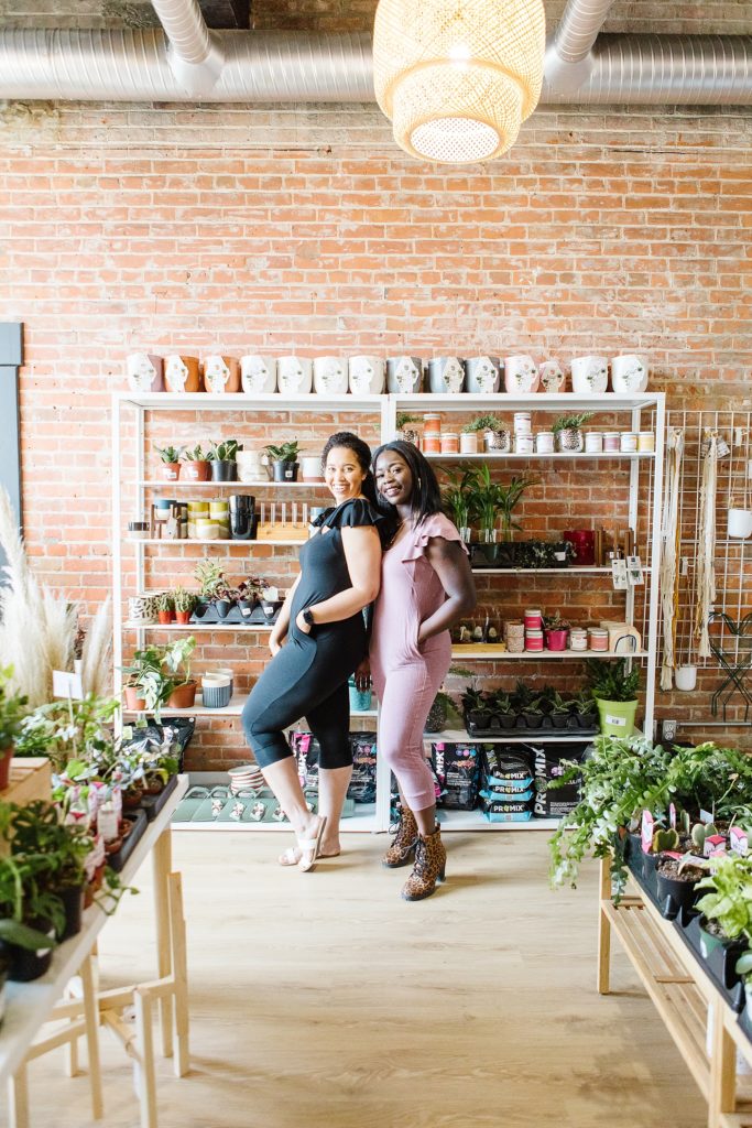 Two models in 4Fold Threads rompers standing in The Sill & Soil plant store