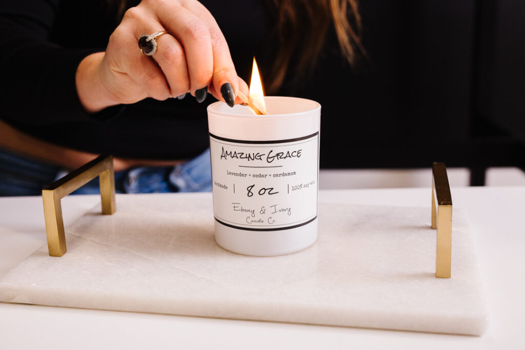 Lighting a candle with a match - Amazing Grace scented candle from Ebony & Ivory, lethbridge product photos by Kinsey Holt Photography