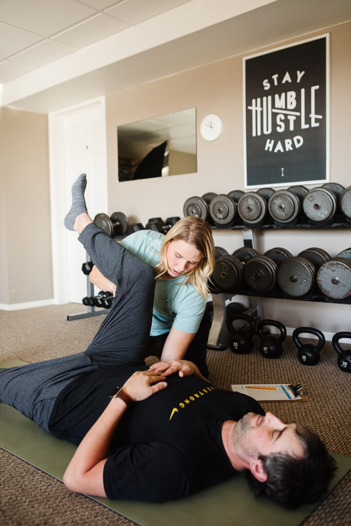 Health and fitness coach Esther Beazer testing mobility in a client in a photograph by Kinsey Holt Photography