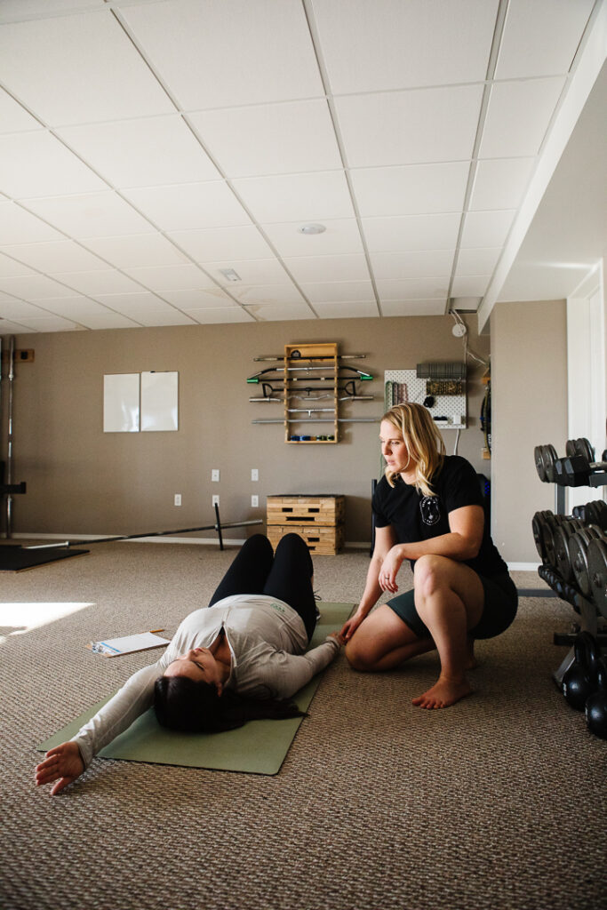 Health and fitness coach Esther Beazer assiting client in a photograph by brand photographer Kinsey Holt