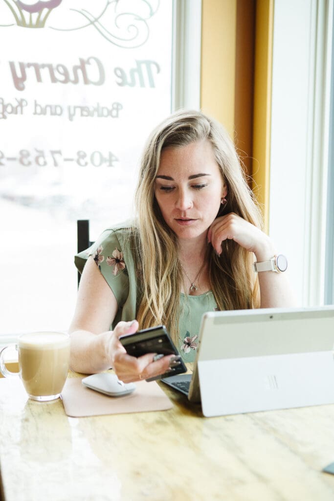 Woman working on laptop in cafe by the window. Realtor brand photos by Kinsey Holt Photography.