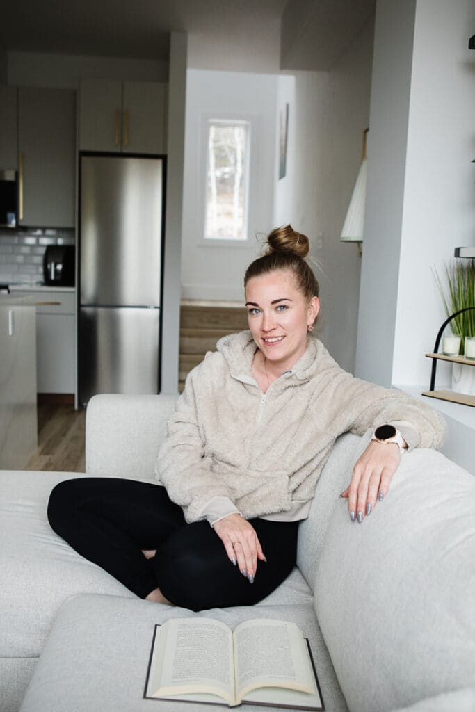 Woman in comfy clothes sitting on couch. Tamara Rzan realtor.